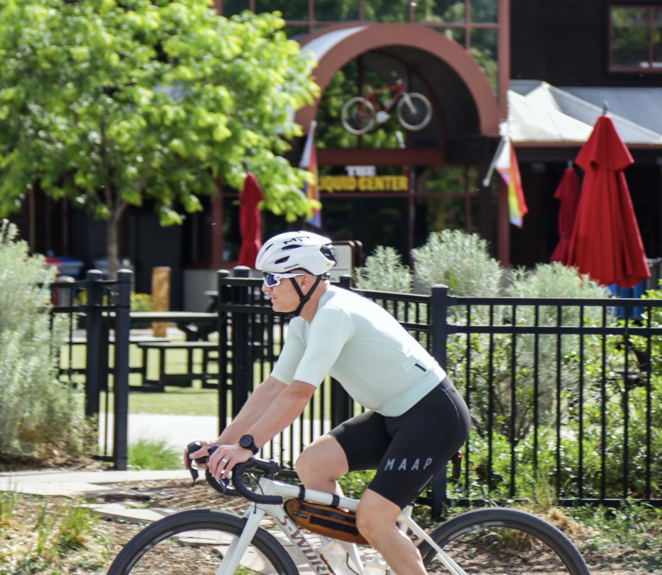 Cyclist wearing a properly fit bike helmet: level on the head, straps in a V around the ear